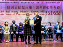 Guest (right) presenting the trophy for the Sai Kung District Outstanding Students Award (Senior Section) to 6M PO Hiu-tung (left)