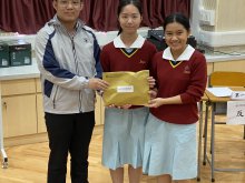 The adjudicator presenting awards to TSUI Man-sze from 4I (left) and CHAN Sin-yi from 4R (right)