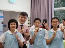 Principal Mr. Ho Chun-yan (left two) posing for photos with students as everyone enjoys their ice creams