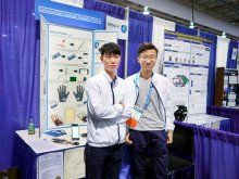 CHAN Ka-lung (left) and CHUNG Ho-fai (right) taking photo in front of the booth of the ‘Sign-Translation Gloves’.