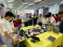 Principal Mr. HO Chun-yan (middle) participating in the AI robotic arm waste classification activities with teachers and students