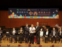 The Honorary Chairperson of Central & Western District Association for Culture & Arts, Dr. LAI Ka-na (middle front) presenting a certificate to Principal Mr. HO Chun-yan (front left) and senior teacher Mr. KWAN Yuk-lun (front right)