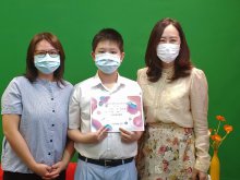SIN Yat-shun from 1M receiving the ‘Most Resemblance Award’ of the ‘One-minute Parent-Child Short Video Competition’, and taking photo with the Principal Dr. POON Suk-han, Halina, MH (right one)